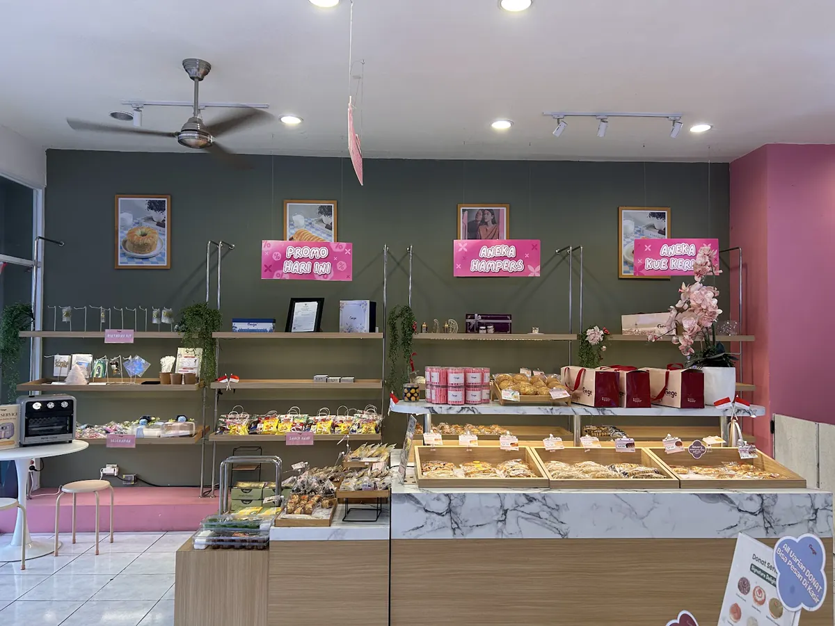 Etalase roti dan rak Gege Bakery dengan dinding hijau serta papan merah muda